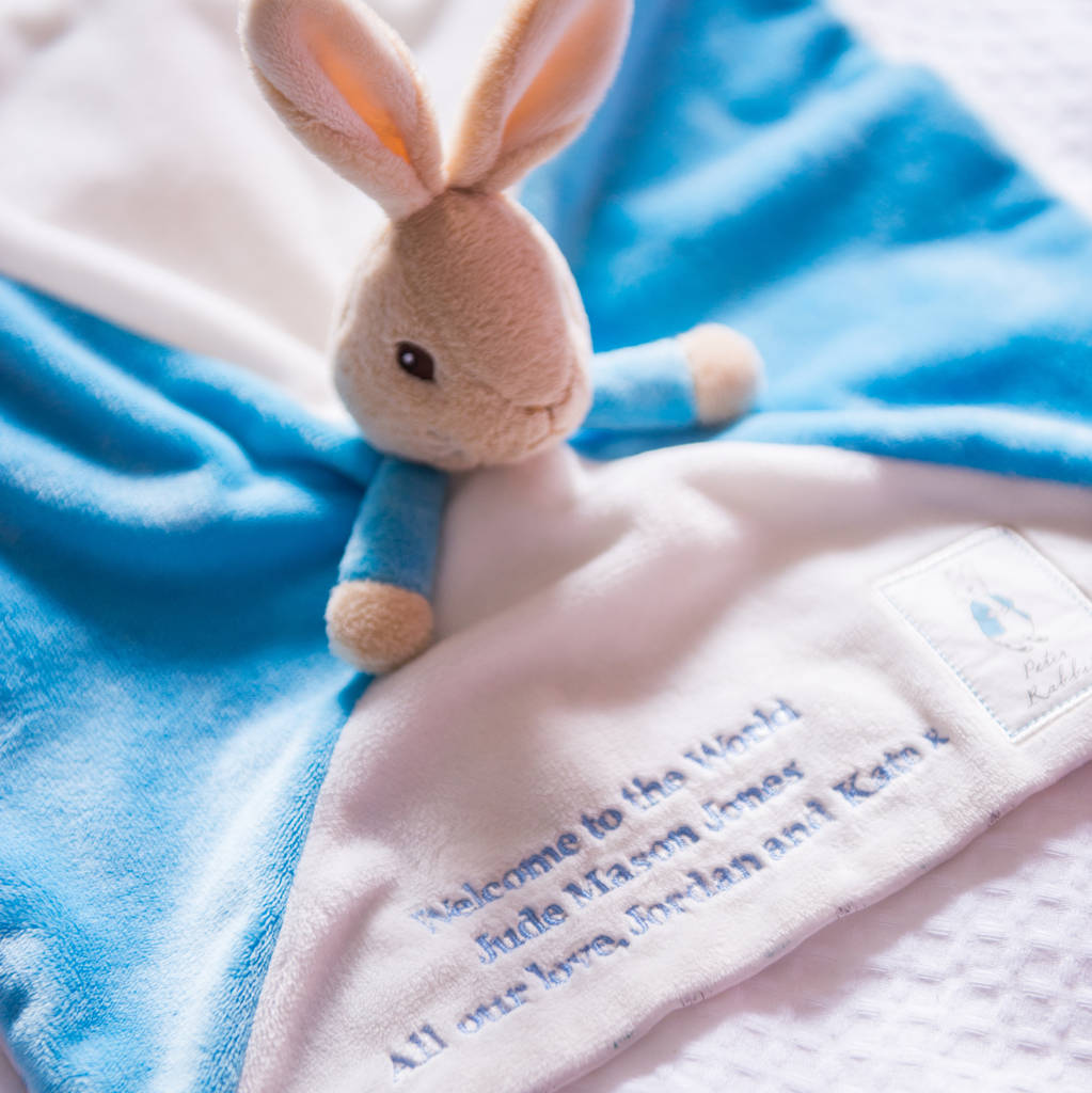 Close-up of Peter Rabbit comforter's soft plush bunny head and blue fleece with printed corner