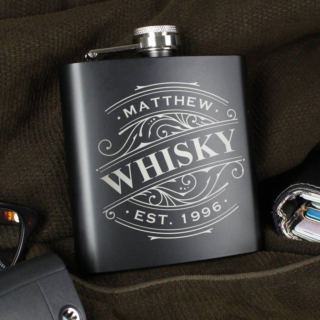 Black whiskey flask with 'Matthew Whisky' engraving on a dark surface