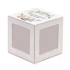 A white cube-shaped gift box with two clear window panels on the front, featuring a printed illustration and the text 'Kashvi Nikols Williams' on the top lid, set against a plain white background.